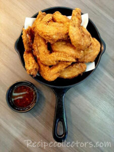 Cinnamon Honey Chicken Wings coated in a sticky honey glaze and served on a rustic platter with fresh herbs.